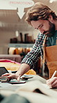 Review, notes or man in workshop with leather, creative insight or stock control in textile factory. Writing, process or artisan with fabric, inventory management or design planning in Australia.