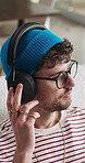 Relax, headphones and man in lounge, thinking and listening to music, reflection and sound. Calm, contemplation and person in home, live streaming for podcast and digital app for radio and audio