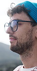 Travel, breathing and man with thinking outdoor for fresh air, holiday reflection or explore scenery. Glasses, tourist or satisfaction on vacation for calm perspective, getaway or nature appreciation