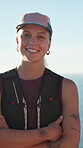 Arms crossed, face and smile with woman hiking at ocean for adventure, hobby or travel. Backpacking, confident and happy with hiker person in nature to explore for discovery, fitness or trekking