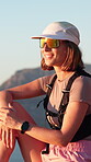 Nature, happy and woman thinking on hiking break to relax, rest and ocean view from mountain. Female person, fitness and trekking outdoor with gear, sunglasses and smile for exercise and health