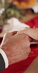 People, holding hands and christmas with dining table for festive tradition or family feast in home. Closeup, social gathering or december holiday with dinner for faith, prayer or event together