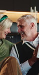 Christmas, gift and couple in home, smile and celebration for festive season, relax and love, Apartment, woman and mature man in lounge, present for Xmas and happiness for tradition, calm and excited