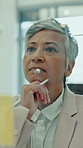 Glass wall, brainstorming and business woman in office for financial strategy, agenda or insight. Sticky note, planning or mature consultant think of investment, project management or problem solving