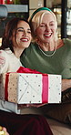 Christmas, present and women in home, hug and celebration for festive season, parent and love, Smile, family and mature mother in lounge, gift for Xmas and happiness for tradition, embrace or excited