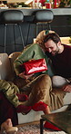 Christmas, gift and people in home, hug and celebration for festive season, gratitude and love. Family, mature woman and man in lounge, present for Xmas or happiness for tradition, embrace or excited