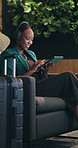 Woman, tablet and business trip in lounge at airport with smile, contact and headphone for music on sofa. Person, smartphone and streaming with app for flight schedule, booking or travel in lobby