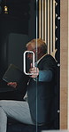 Businessman, booth and laptop with project at office by glass door, proposal or job at insurance company. Mature person, broker and computer in isolation pod for risk management career at agency