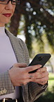 Businesswoman, walk or commute in park with phone, text message or good news for real estate work. Happy, female person and glasses outdoor with tech, mobile app notification or travel to realtor job
