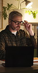 Night, thinking and businessman with laptop in office, creative and editing article for publication. Serious, magazine editor and mature person with tech, glasses and working late for story deadline
