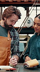 Talking, people and fabric sample in warehouse, leather manufacturing and writing for material choice. Textile production, discussion and worker with client in factory, cloth order and decision notes