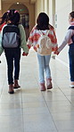 School, walking and back of children in hallway ready for education, class and learning together. Academy, friends and students in corridor holding hands for knowledge, development and lesson