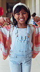Girl, face and flex with muscle at school in corridor with smile, confident and excited for learning. Child, happy and strong with bicep, portrait or scholarship for development on hallway at academy
