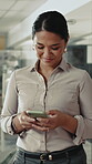 Woman, walking and typing in office with phone, text message or check email for business communication. Person, scroll and smile in workplace with tech, mobile app or website for company notification