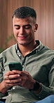 Man, relax and typing on couch with phone, check social media post and online dating site notification. Happy, person and scroll in home with tech, mobile app and connectivity for text message alert.