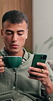 Man, phone and blowing coffee at house to start day, social media and browsing website. Serious, person and warm beverage with mobile for chat, communication and notification for text message in home