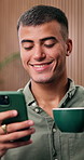 Smile, man and coffee with phone at house to start day, social media and browsing website. Happy, person or warm beverage with mobile for chat, communication and notification for text message in home