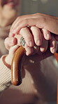 Caregiver, old woman and holding hands in house with walking stick, empathy and support in retirement. Understanding, volunteer and person with disability, comfort and sympathy in nursing home.