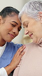Old woman, nurse and smile in home for hug, memory or touch forehead with assisted living services. People, caregiver and senior patient with embrace, connection or support for wellness in retirement