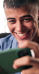 Video game, cellphone and man in home, playing for competition and smile for victory. Smartphone, mobile user and person with happiness, excited and digital app for virtual esports and entertainment