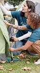 Volunteer, women and pitch tent at summer camp for gear security, outdoor adventure or preparation. Counselor, teamwork and shelter set up on campground for holiday program, assemble rope or safety