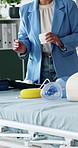 Hands, presentation and training with bandage with first aid, teaching and gear with dummy on gurney. Person, coach and talk at workshop with discussion, equipment or explain with cloth for emergency
