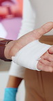 Hands, first aid and workshop with bandage at office, teaching and staff training with gloves for help. Person, coach and cloth in workplace with gauze, learning and demonstration for emergency