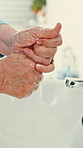 Senior, person or washing hands with soap in bathroom sink for hygiene, disinfection or cleaning. Closeup, elderly or rinsing with disinfectant for skincare, bacteria or germ and dirt removal in home