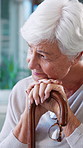 Walking stick, thinking and senior woman in home with nostalgia, memory or loneliness in living room. Sad, reflection and elderly female person with wooden cane for medical aid with daydreaming.