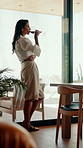 Thinking, relax and woman with wine in home for weekend, good mood and chill on break. House, window and mature person with alcohol, drink and glass for inspiration, reflection and daydreaming