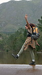 River, freedom and happy woman on holiday, hiking and backpacker with balance in nature or adventure. Outdoor, trekking and African person with smile on vacation, explore and playful walk on getaway