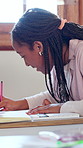 Writing, teenager and girl with exam in classroom for assignment, growth and development. Education, test and problem solving with student in high school  for knowledge, learning or scholarship