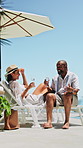 Wine, conversation or mature couple at resort, anniversary celebration trip or travel holiday for bonding. Talk, alcohol or people on deck chair for summer vacation, interracial relationship or smile