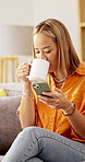 Happy, phone and woman on sofa with coffee for social media, internet and online chat on weekend. Home, relax and person on smartphone for typing message, website and connection with warm beverage