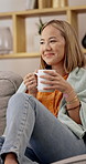 Woman, coffee and thinking with scent on sofa, relax and smile with memory, reflection and break in home. Asian person, cup and happy with perspective, chill or beverage in living room at apartment