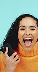 Winner, shouting and woman with phone in studio for online bonus, lottery success and good news. Excited, happy and portrait of person on smartphone for winning, surprise and prize on blue background