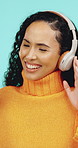 Happy, dancing and woman with headphones in studio for online streaming, music app and subscription. Dancer, energy and person listening to audio, radio and playlist for good mood on blue background