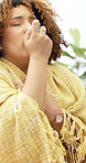 Woman, inhaler and sick on sofa with blanket, medicine and spray with chest pain in living room at home. Person, asthma pump and recovery on couch, rest or breathe for healing with wellness at house