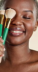 Happy, makeup brush and beauty with black woman in studio for self care, glow and foundation. Cosmetics, highlighter shine and cosmetology with person on white background for eyeshadow and blush