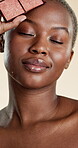 Face, makeup and beauty with black woman in studio for self care, glow and foundation. Cosmetics, highlighter shine and cosmetology with person on white background for eyeshadow palette and blush
