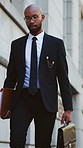 Black man, lawyer and walking with briefcase in city for corporate travel, law or career ambition. Person, employee or attorney in street, mission or bag for court case, opportunity or legal advice