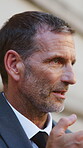 Serious, businessman and phone call in city, loudspeaker and discussion with contact for court case. Outdoor, mature attorney and person with mobile for communication, commute and planning for trial