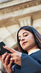 Typing, lawyer and woman in city with phone for contact, networking and update for legal trial. Attorney, low angle and person on cellphone for connection, message and advice for court case in town