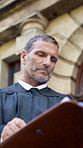 Judge, man and documents with thinking in city for court case, review and notes with legal career. Mature person, magistrate and low angle with folder, legislation or justice with insight for report