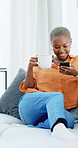 Black woman, coffee and phone on home sofa for reading funny post, blog update or texting online. African person, drinking tea and relax on couch with technology, social media and smile for app