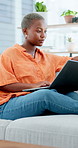 Laptop, student and woman in home, typing and email for university application, results and smile. Apartment, college and African person on sofa, pc for research proposal and website for assessment