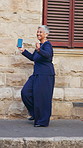Earphones, dance and mature businesswoman in city with good news, achievement or finance project approval. Smile, energy and female financial manager with groove for job promotion in urban town.