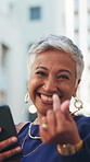 Face, employee and woman with wink, phone for connection and success for profit growth. Mature person, outdoor and hand gesture in city, online chatting or reaction for bonus, excited and promotion