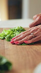 Cooking, hands and woman cut vegetables in kitchen for healthy recipe, vegetarian diet or nutrition. Food, mature person and fresh lettuce in home for meal preparation, lunch process and vegan dish