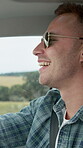 Man, happiness and drive for travel with talking, road trip or getaway in car for countryside vacation. Person, traveler or smile for holiday, transportation and driver in funny conversation on break